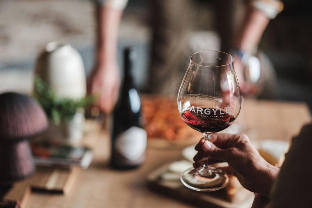 A person holding a glass of red wine.
